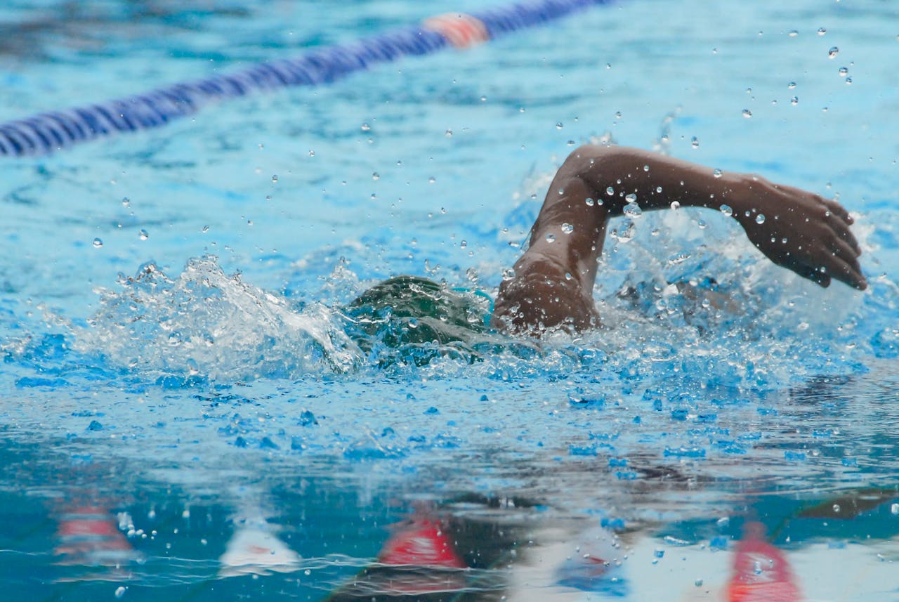 Athlete swimming freestyle in a clear pool with splash and motion